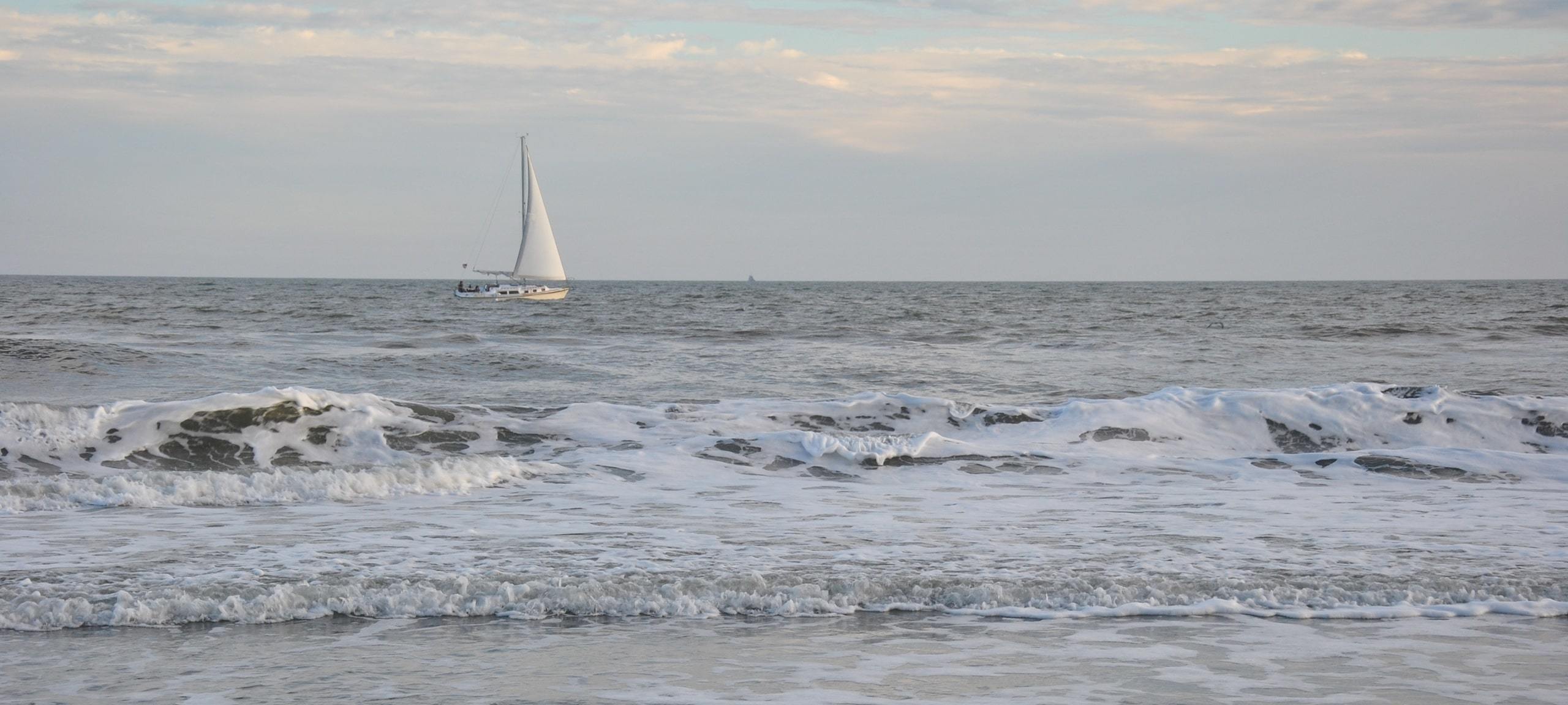 Lone sailboat out on Jersey Shore water during early morning